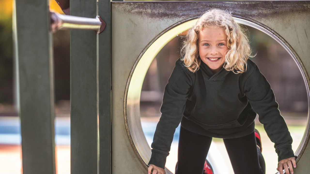 Young student on outdoor playground equipment