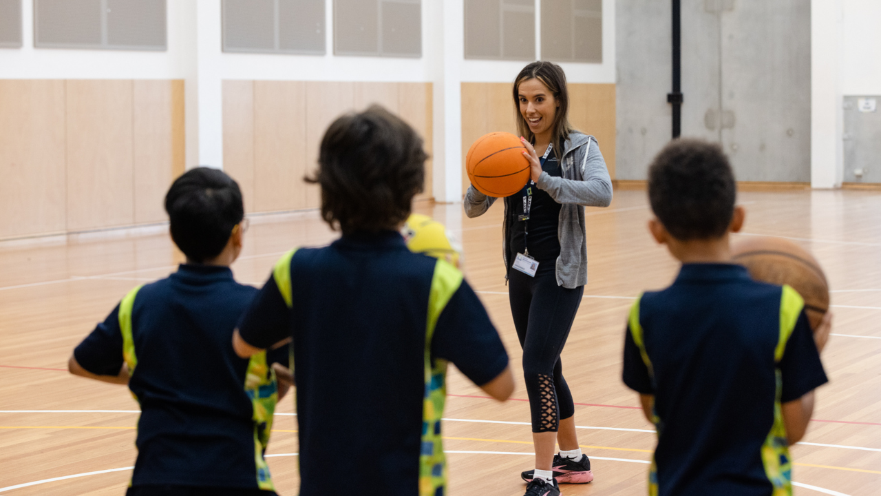 Teacher playing basketball with three students