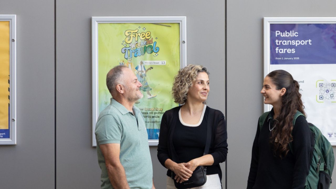 Parents standing with their daughter on a train platform